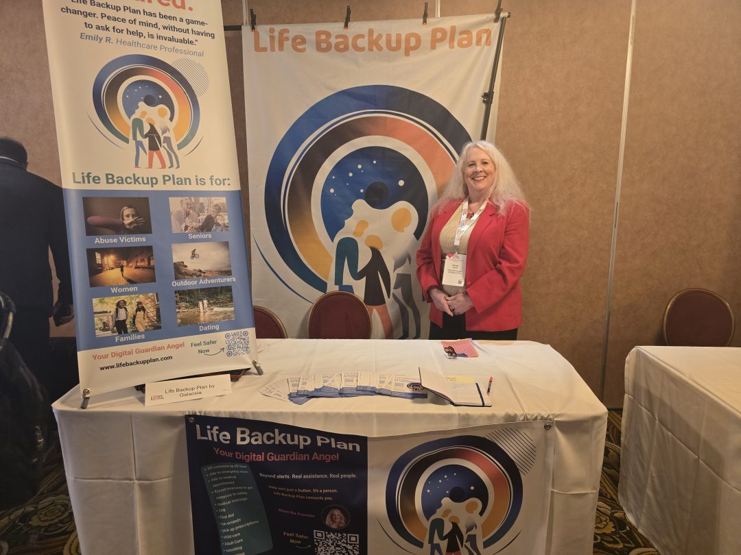 Sandy Eulitt, CEO and Founder of Life Backup Plan by Galacxia, Inc., standing in her booth with front banner, table banner showing the digital health mobile app use cases depicted in a gallery for booth aboard the Queen Mary in Long Beach, California for the TiE Global Angel Investor Summit 2025