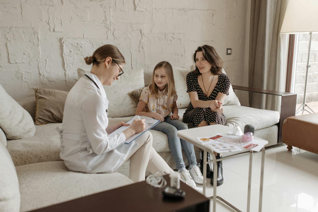 Healthcare worker completing a patient intake form with a child and her mother demonstrating the importance of accurate medical data sharing, which life backup plan provides. Life Backup Plan has created a complete electronic patient intake form, for faster and more accurate communication of vital information to healthcare workers.